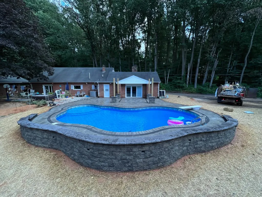 Freeform raised pool wrapped in a full stone wall